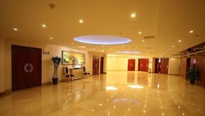 A spacious lobby with a polished floor, a reception desk, and a large circular light fixture on the ceiling. - Huashan Mountain International Hotel (Xi'an)