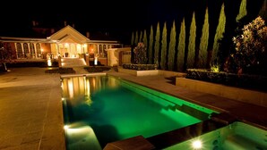 A nighttime view of a swimming pool with a house in the background. - Freeman On Ford (Beechworth)
