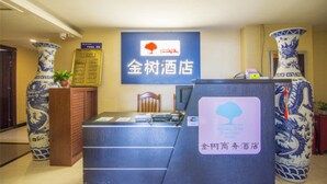 A reception desk with a sign for 'Golden Tree Hotel' and a blue and white vase. - Golden Tree Business Hotel (Xi'an)
