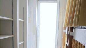 A room with a window, wooden floor, and shelves with measuring tapes. - OCHO Guest House - Hostel (Sapporo)