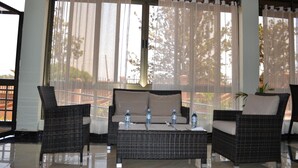 A room with a sofa set, two armchairs, and a coffee table. There are water bottles on the table. - Interservice Hotel (Kampala)