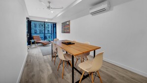 A modern dining area with a wooden table, six chairs, and a ceiling fan. - All on Flinders (Melbourne)