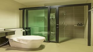 A modern bathroom with a glass-enclosed shower, a toilet, and a sink. - The Rich Sotel (Krabi)