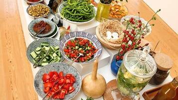 A buffet table with various dishes and fresh vegetables.