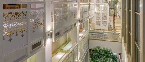 A multi-level atrium with skylights, decorative panels, and a central indoor garden.