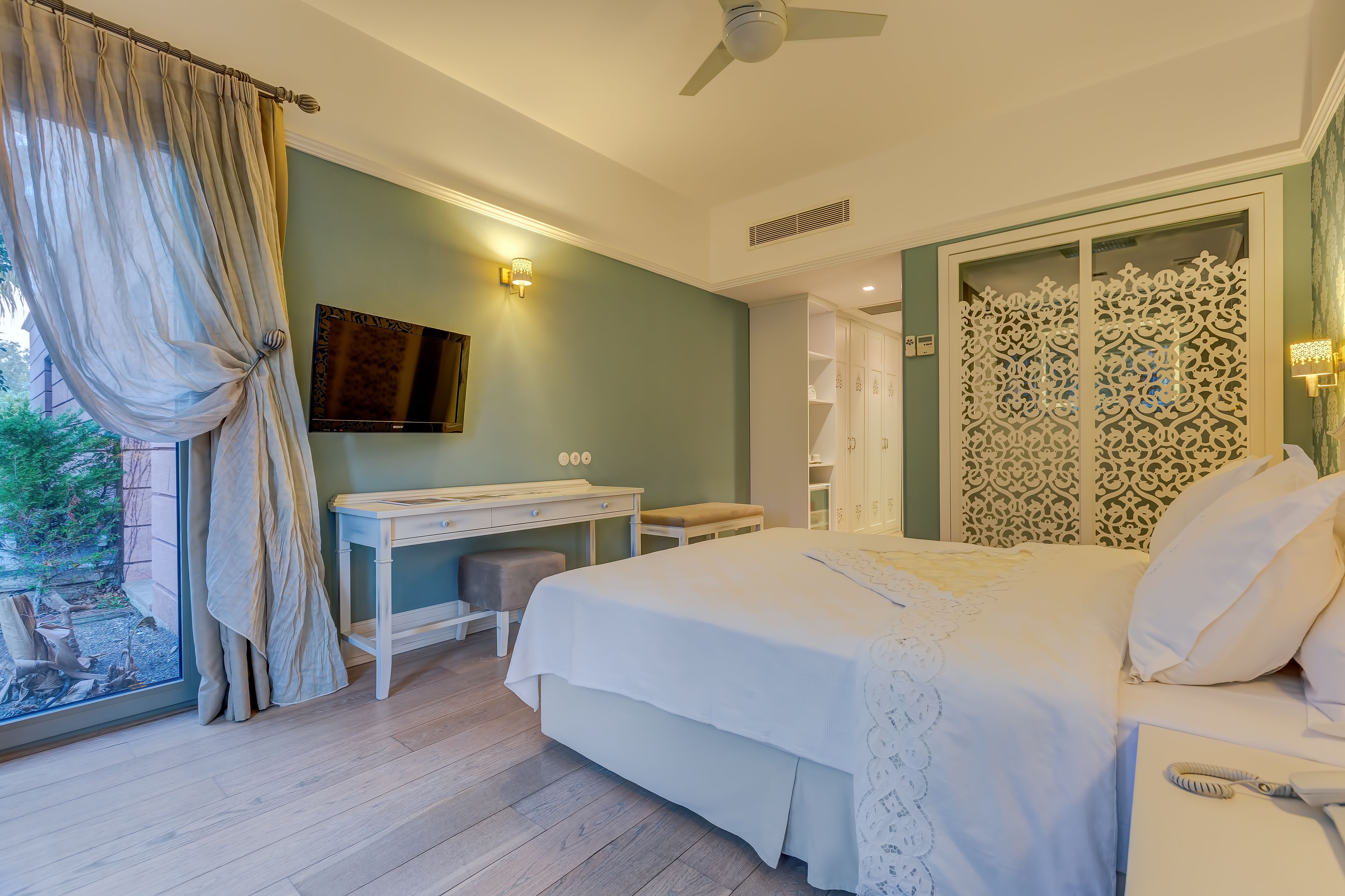 A bedroom with a bed, desk, and wardrobe.