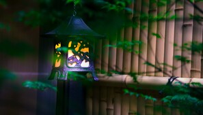 A lantern with a cat design, hanging against a bamboo backdrop. - KumoMachiya Nijojo (Kyoto)