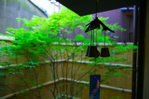 A bird feeder with a blue tag hanging in front of a window. - KumoMachiya Nijojo (Kyoto)