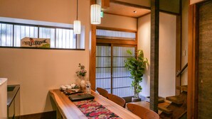 Um quarto japonês tradicional com tatames, uma mesa de madeira baixa e uma porta de tela deslizante shoji.