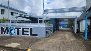 Entrada de un motel con un letrero que dice 'MOTEL' y 'BLACK MARLIN MOTEL'.