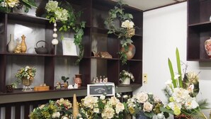 Ein Zimmer mit dunklen Holzböden, die verschiedene Dekorationen und Blumen zeigen.