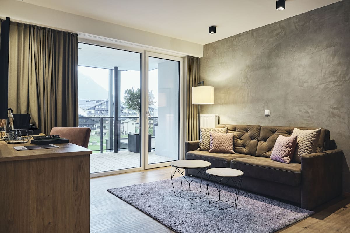 Una sala de estar moderna con un sofá, un escritorio y una lámpara.