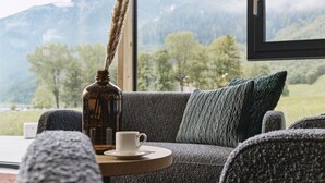 A cozy seating area with a view of mountains and trees. - Hotel Auszeit (Eben am Achensee)