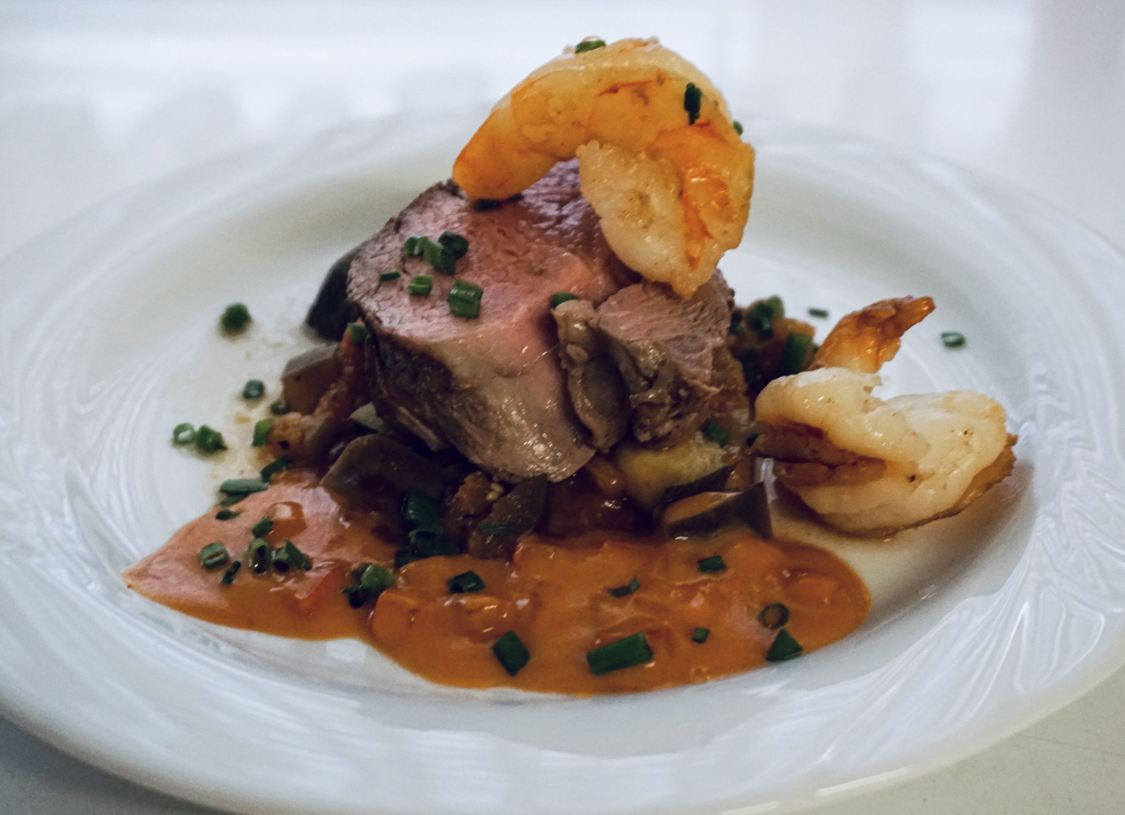 Ein Teller Essen mit Fleisch, Gemüse und Soße.