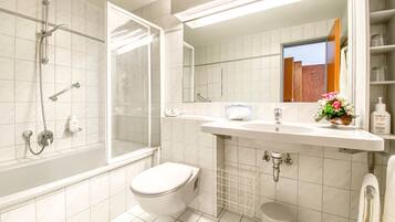 Un bagno con doccia, toilette, lavandino e specchio.