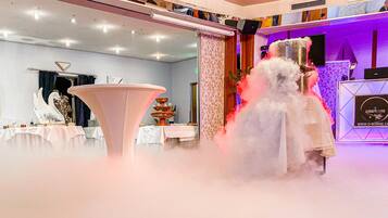 A formal event with a stage, a large decorative fountain, and a tiered cake display.