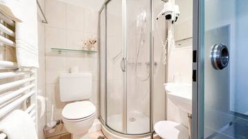 A modern bathroom with a glass-enclosed shower, a toilet, and a sink.