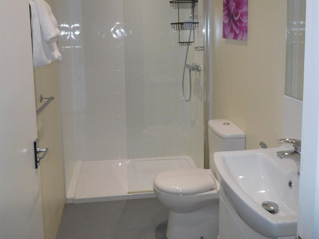 A bathroom with a shower, toilet, and sink.