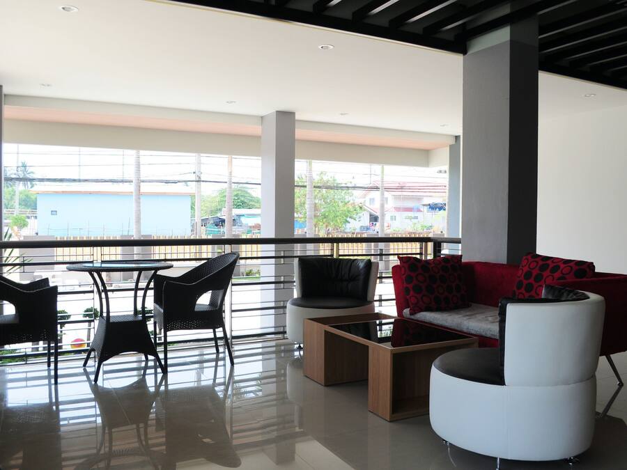A modern indoor space with a balcony, black and white furniture, and large windows.