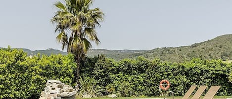 Una piscina al aire libre de temporada, sombrillas