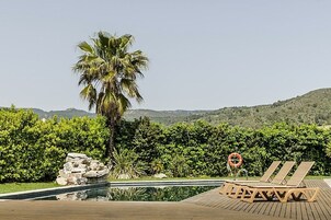 Una piscina al aire libre de temporada, sombrillas