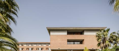 A hotel with a modern design, featuring a flat roof and a brick facade.