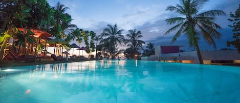 Una piscina al aire libre, una piscina con borde infinito, tumbonas