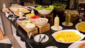 A buffet with various food items including salads, fruits, and desserts. - Socool Grand Hotel (Nang Rong)