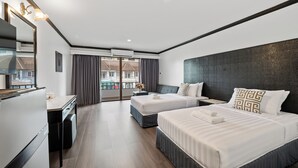 Une chambre d’hôtel avec deux lits, un bureau et une grande fenêtre avec des rideaux.