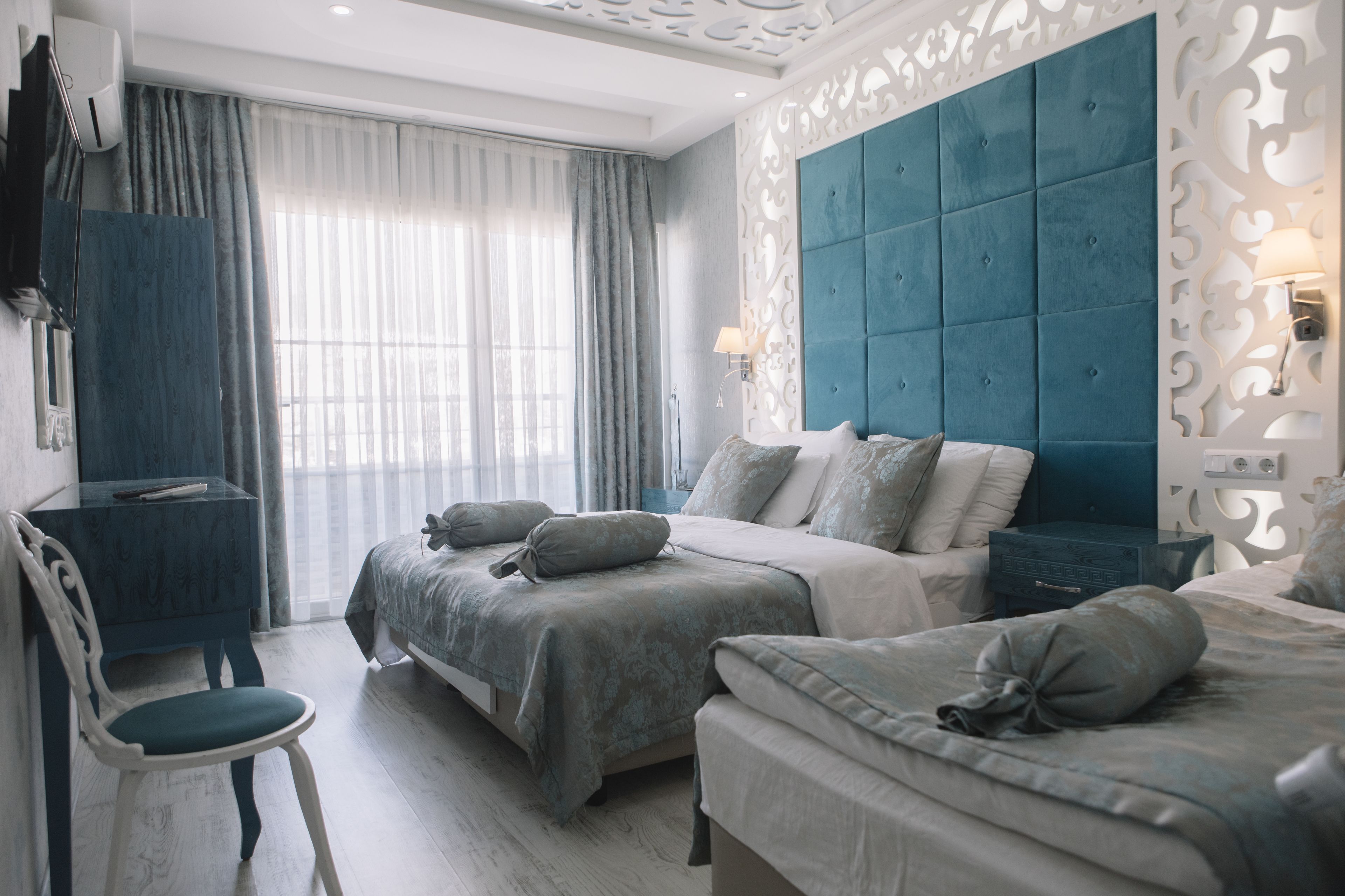 Une chambre d’hôtel avec deux lits, un bureau et une chaise.