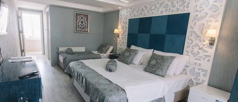 A modern bedroom with a large bed, two bedside tables, and a decorative ceiling.