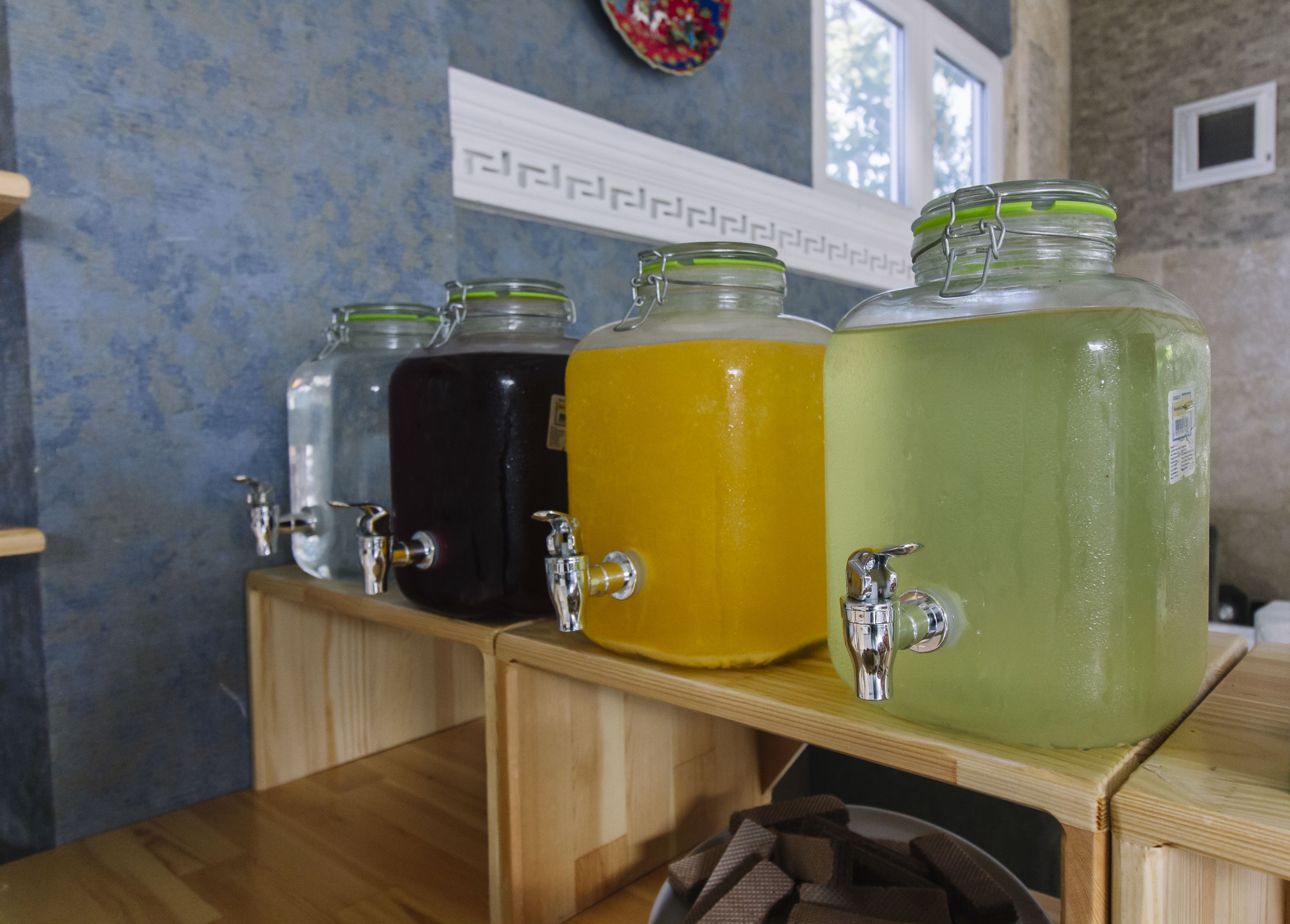 A beverage dispenser with four different colored drinks.