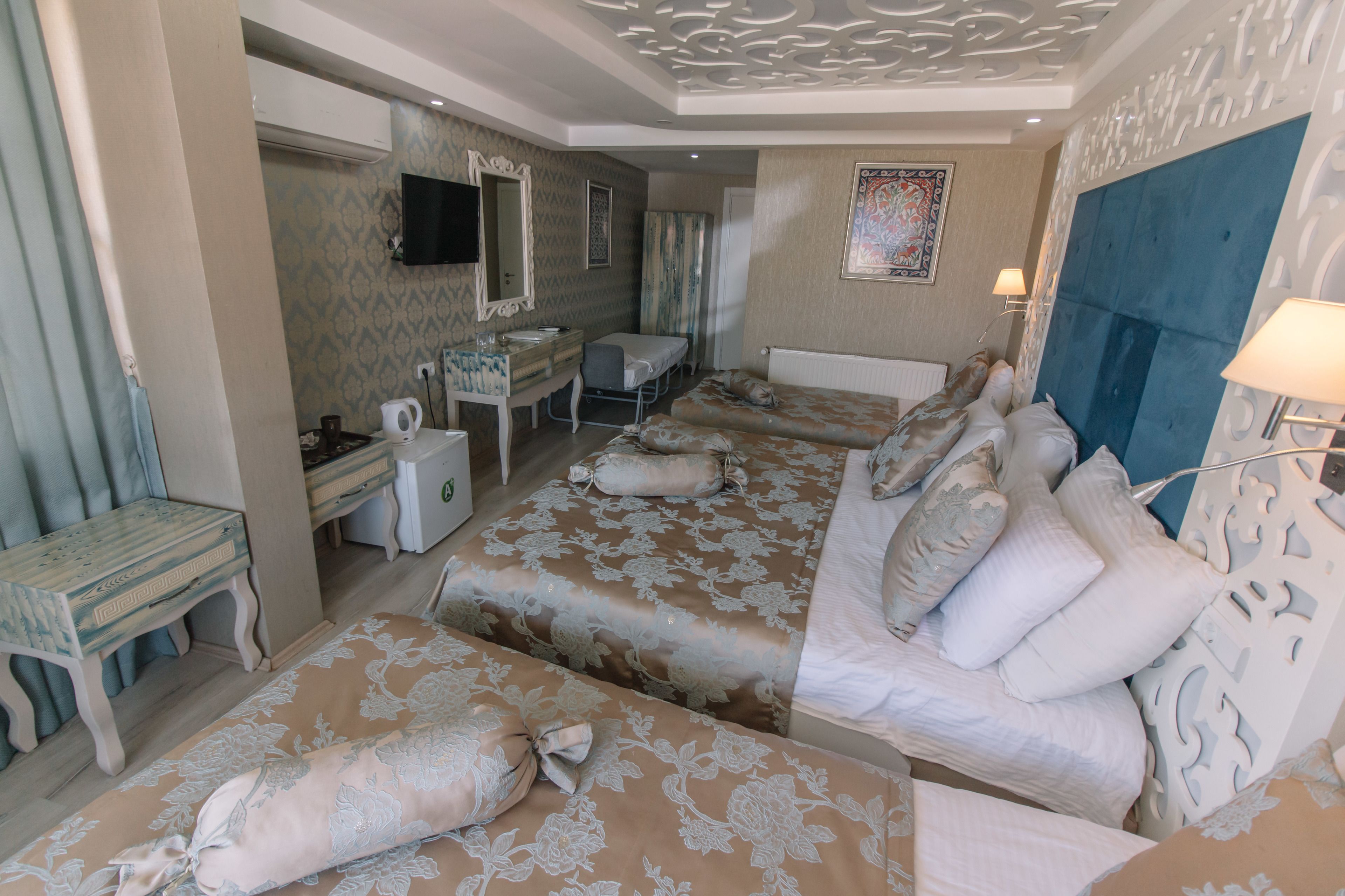 A hotel room with two beds, a desk, a chair, a television, and a bathroom.