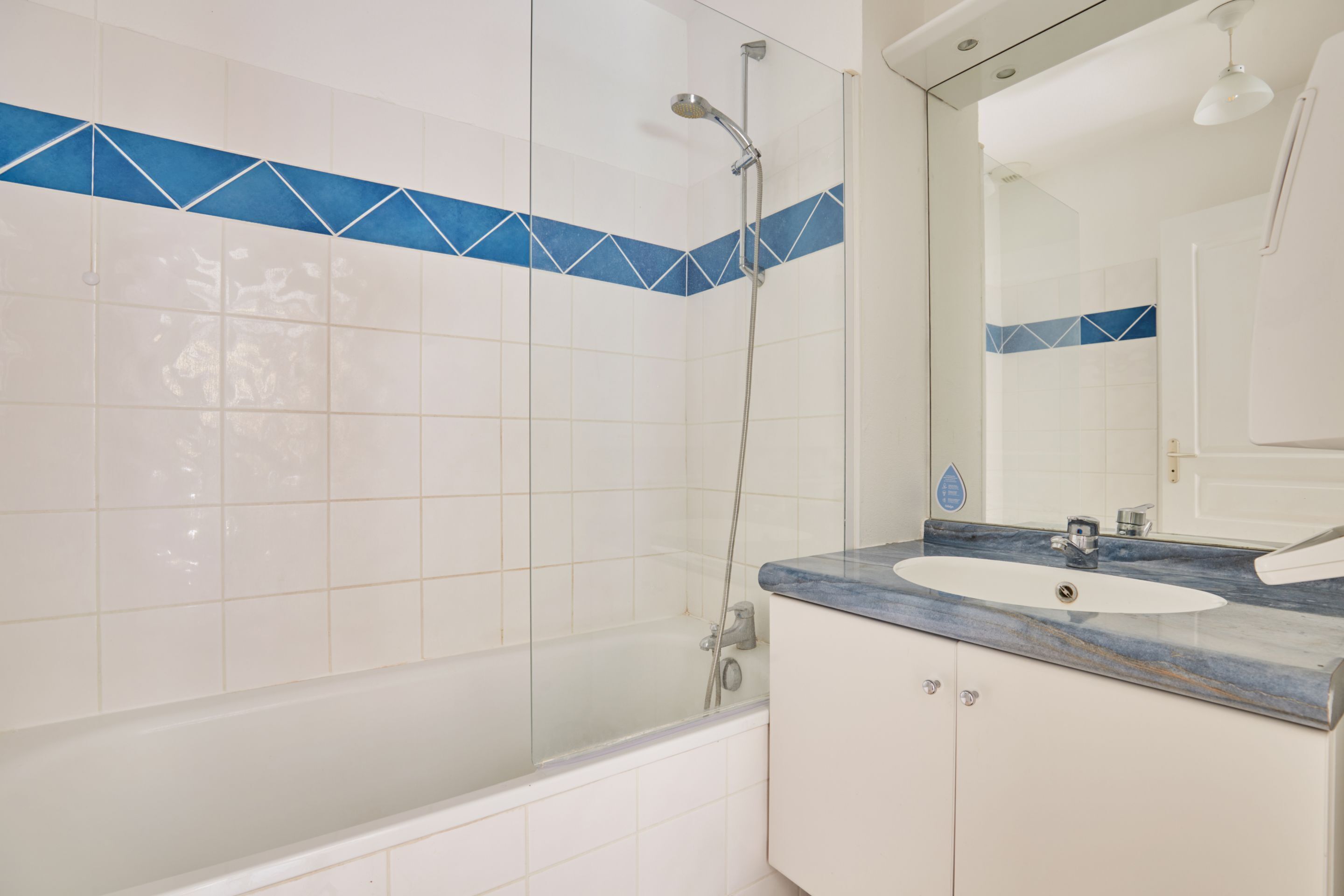 Ein Badezimmer mit Badewanne, Dusche, Waschbecken und Spiegel.