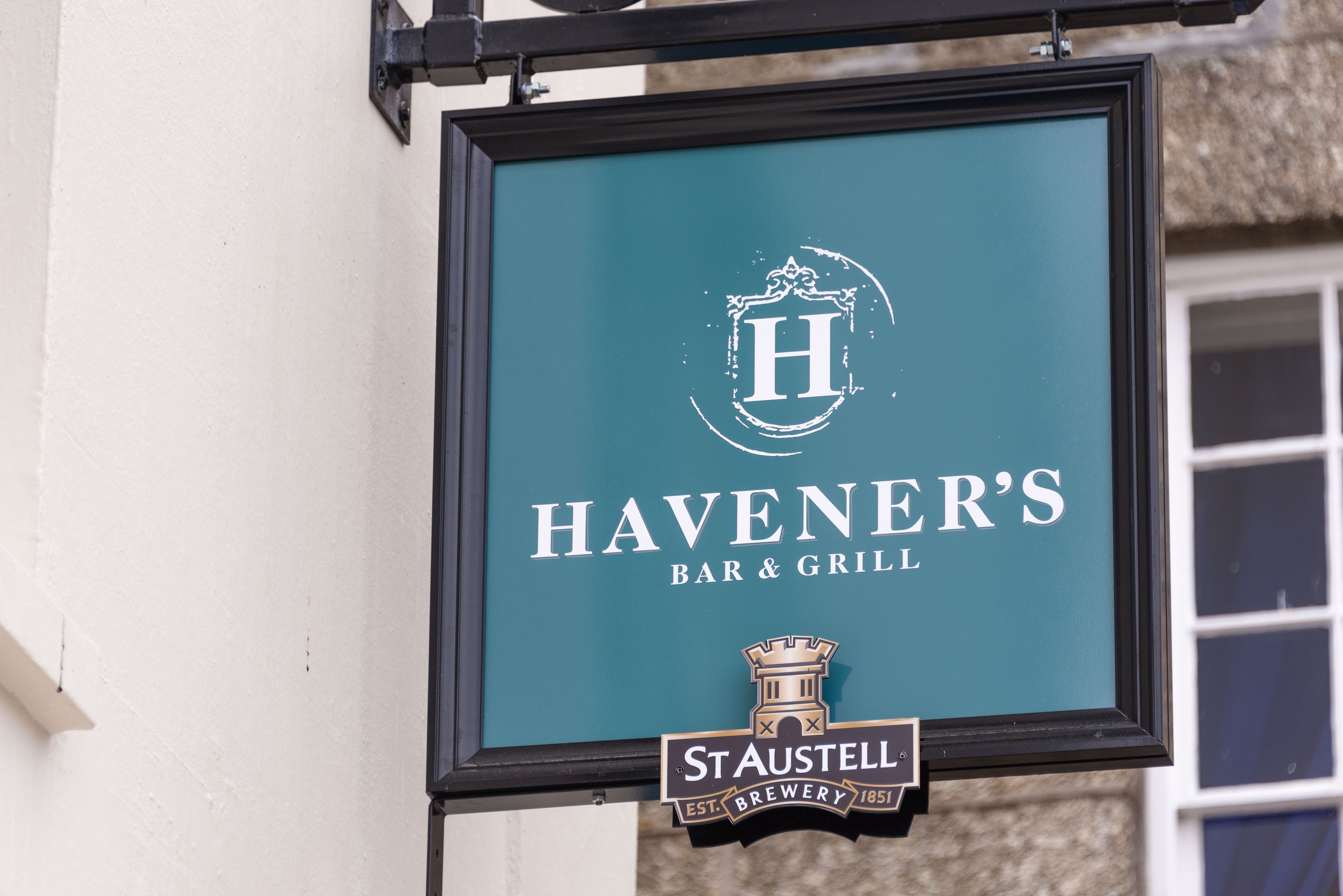 A sign for Havener's Bar & Grill with a logo and establishment year.