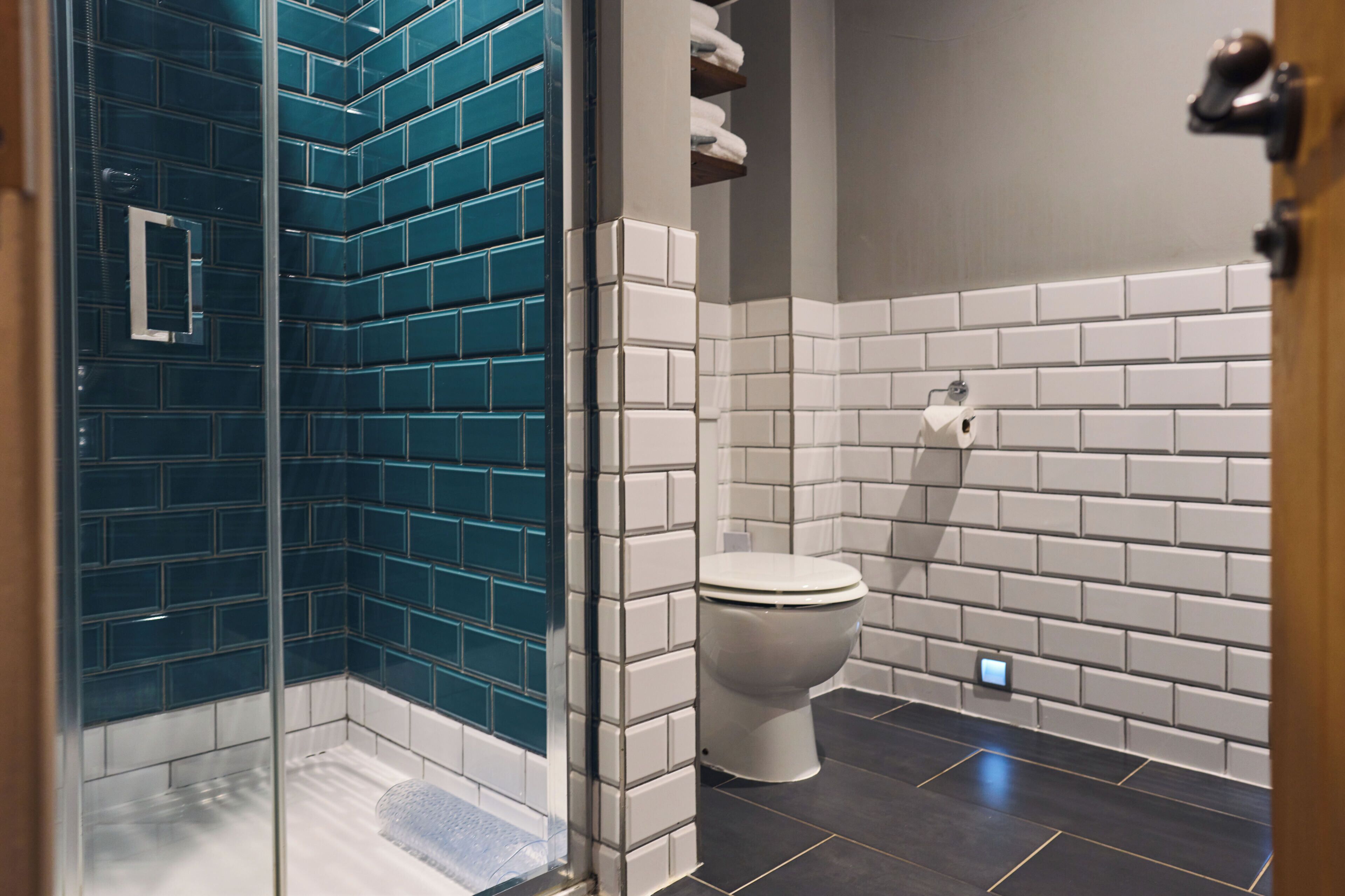 A bathroom with a shower area and a toilet.