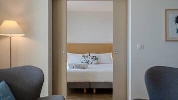 Quarto de hotel com cama, escrivaninha e cadeira.