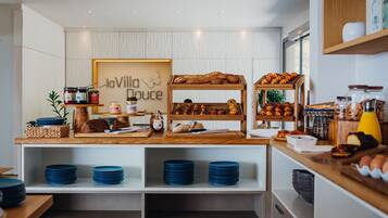 A breakfast buffet with various pastries, bread, and condiments.