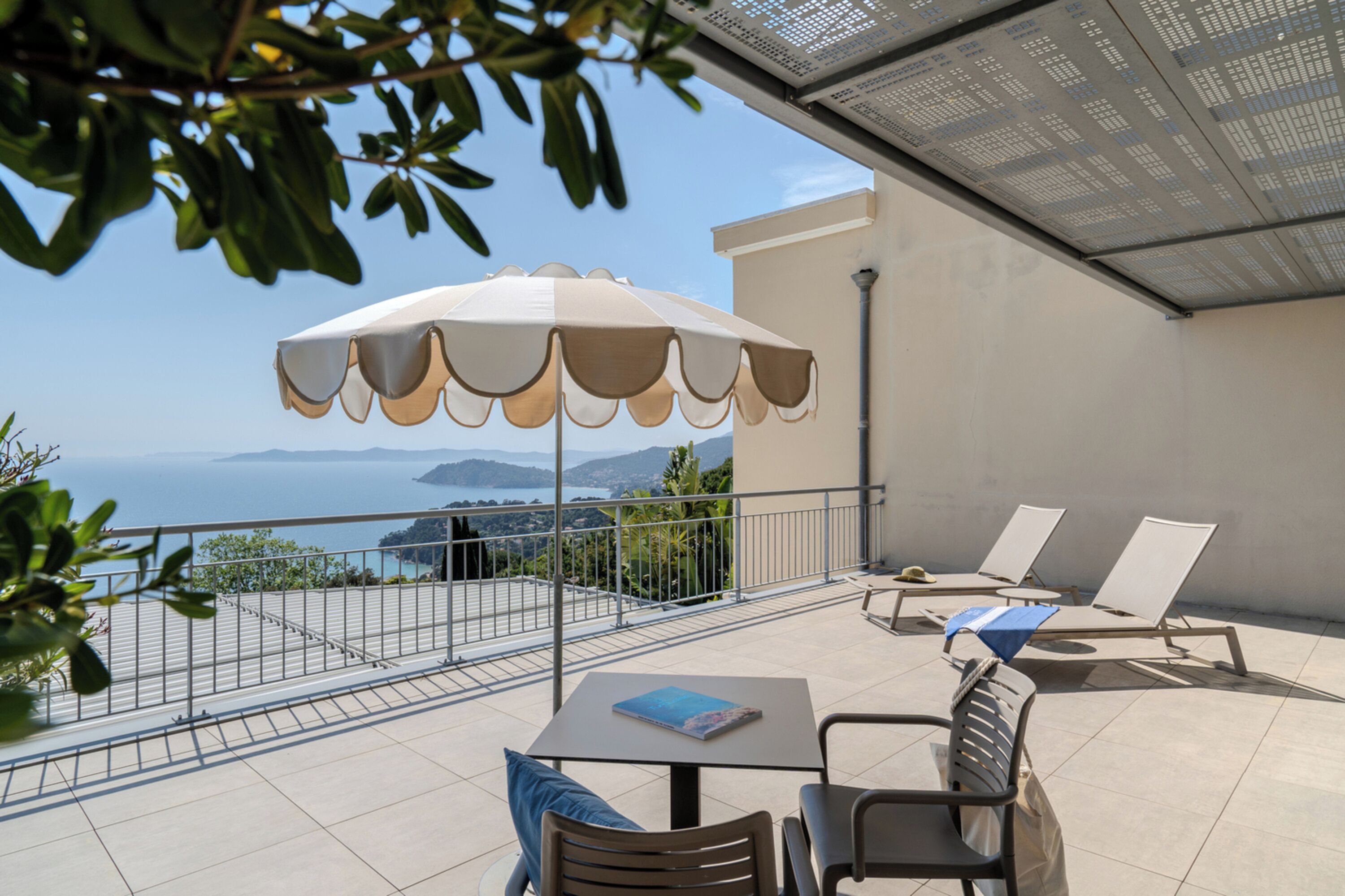 Ein Balkon mit Tisch, Stühlen und Sonnenschirm.