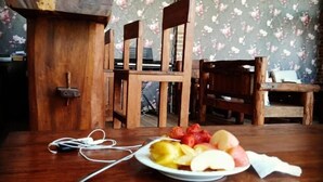 A wooden table with a plate of fruit and a pair of earphones.