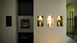 Un interior moderno con chimenea, iluminación empotrada y plantas en macetas.