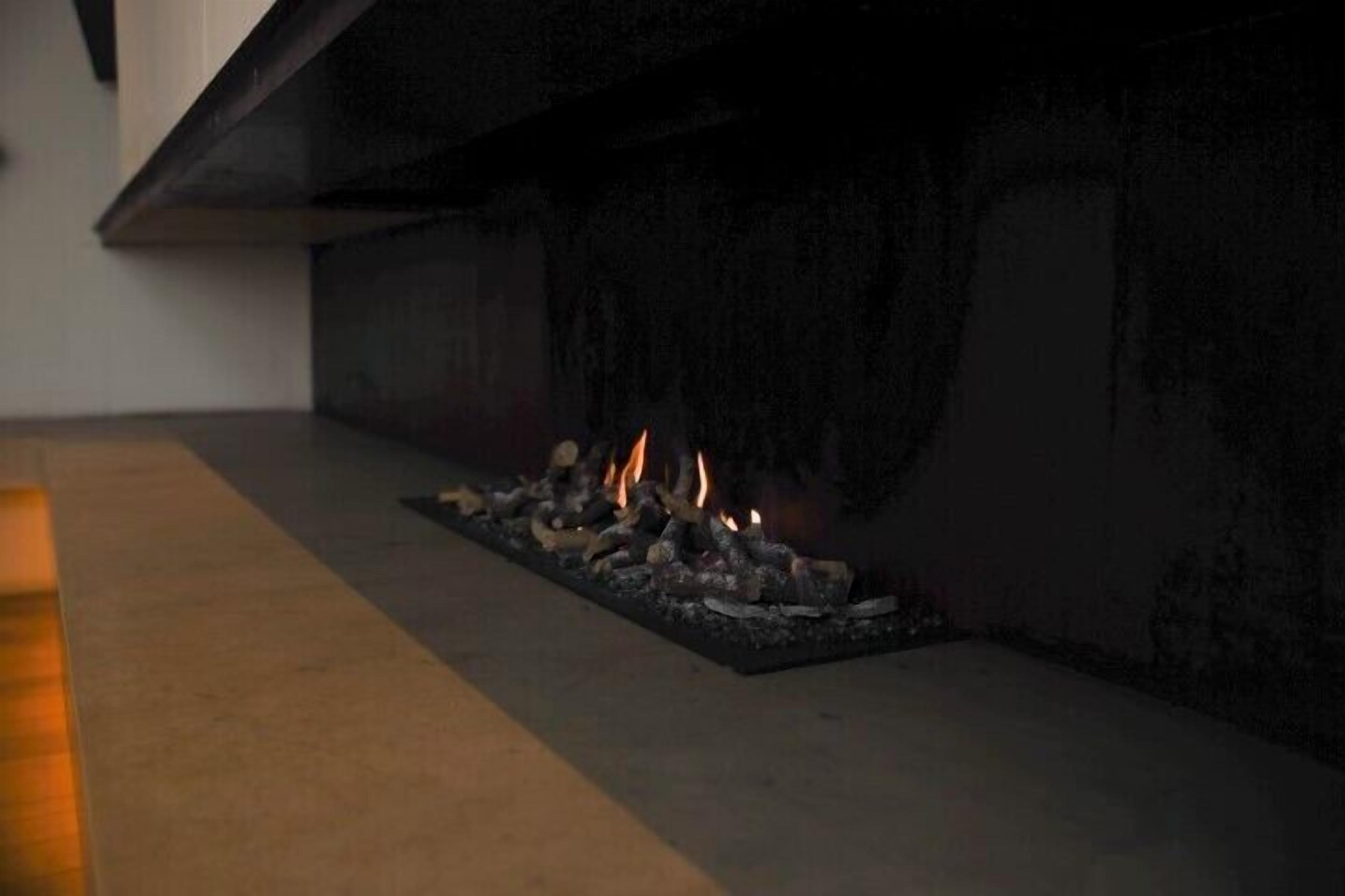 Ein moderner Kamin mit minimalistischem Design, gekennzeichnet durch eine elegante schwarze Umrandung und ein aufgeräumtes Erscheinungsbild.