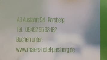 Señal de hotel con la dirección A3 Salida 94 - Parsberg, número de teléfono 09492 95 93 182 y sitio web www.maiers-hotel-parsberg.de.