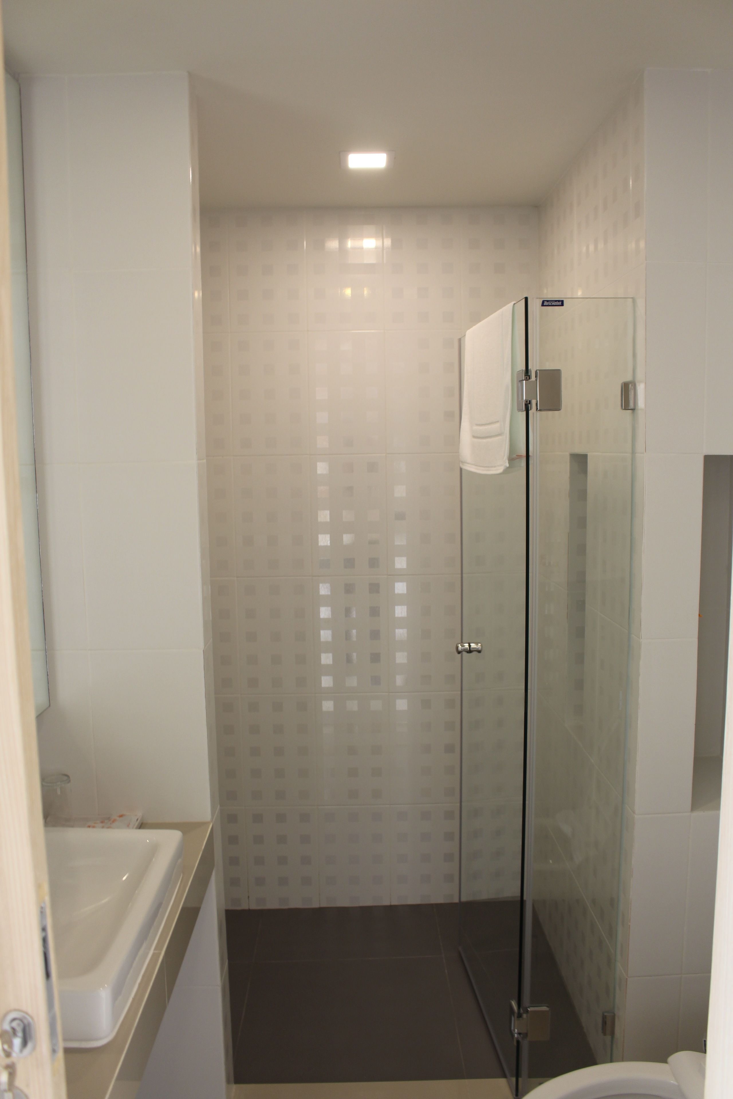 Un baño con cabina de ducha de vidrio, bañera y retrete.
