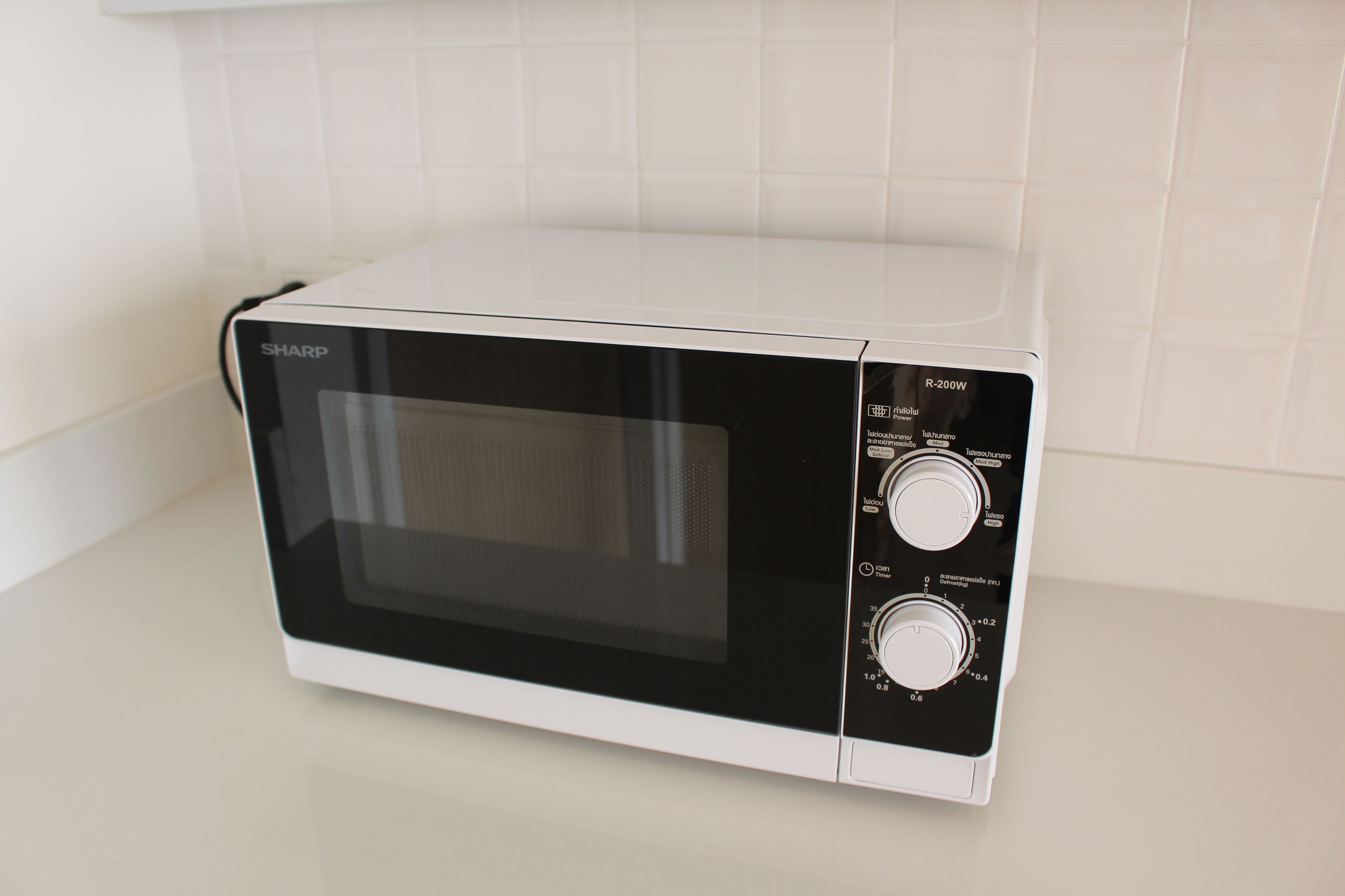 A white Sharp microwave oven with two dials on the right side.