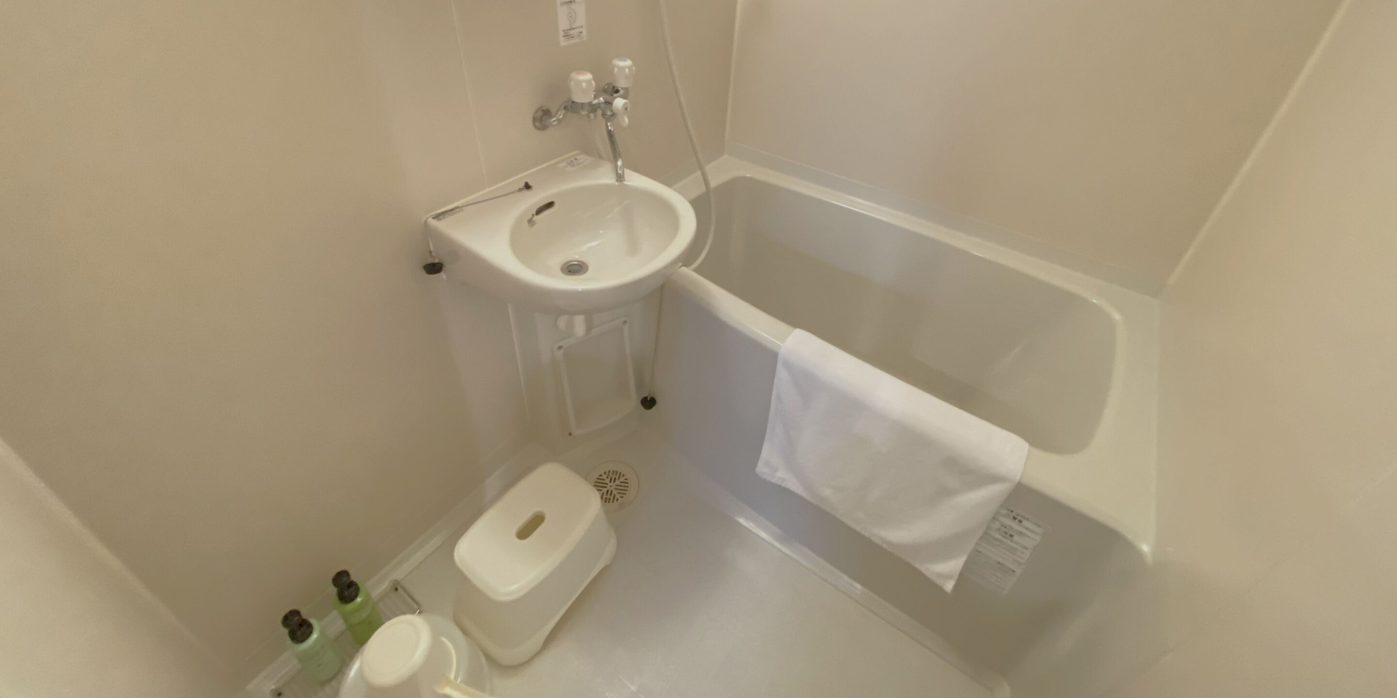 A small bathroom with a white sink, a toilet, and a bathtub.
