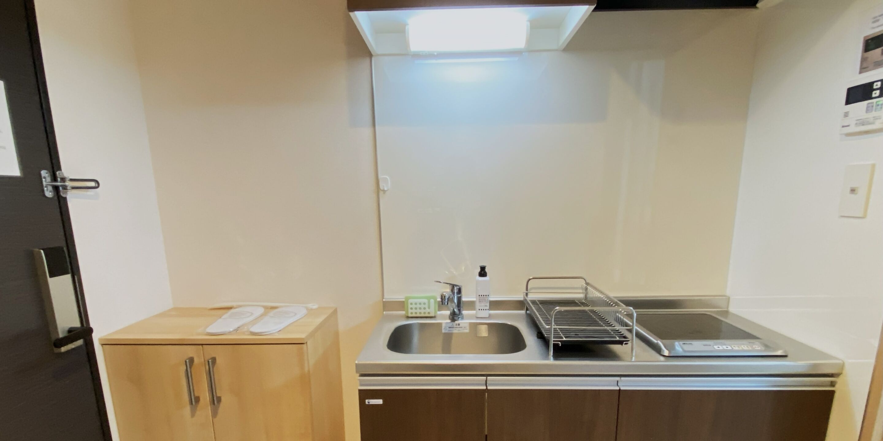 Una cocina compacta con un lavamanos, un mueble pequeño y una encimera.