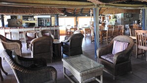 A restaurant with wicker furniture, a bar area, and a pool table. - Roaring Sky (Cullinan)