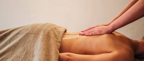 Une personne reçoit un massage du dos sur une table de massage.