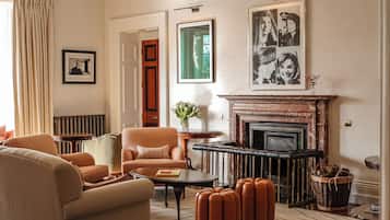 Una sala de estar con chimenea, un sofá, una mesa de centro y una lámpara.
